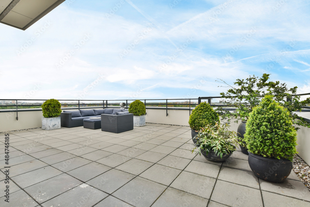 Abgedichtete und mit Platten belegte Dachterrasse mit Sitzgruppe und Kübelpflanzen